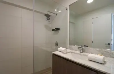 a bathroom with a sink and a shower with a mirror at One By Wynwood House in Lima