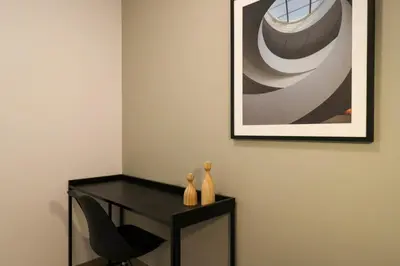 a black desk with a chair and a picture on the wall at One By Wynwood House in Lima