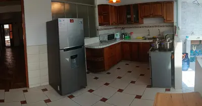 a kitchen with a stainless steel refrigerator and a tiled floor at WaskarWasi in Cusco