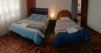 a room with two beds and a lamp at WaskarWasi in Cusco