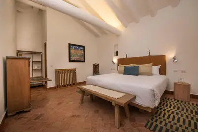 a bedroom with a large bed and a wooden table at Casa Clara by Ananay Hotels in Cusco