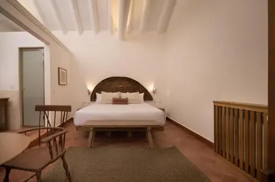 a bedroom with a white bed and a chair at Casa Clara by Ananay Hotels in Cusco