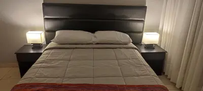 a bedroom with a bed with two lamps on both sides at Lima Airport Sumaq Home in Lima