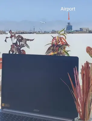a laptop computer sitting on top of a table with plants at Lima Airport Sumaq Home in Lima