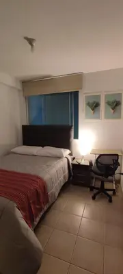 a bedroom with a bed and a desk and a chair at Lima Airport Sumaq Home in Lima
