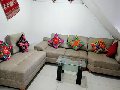 a living room with a couch with colorful pillows at HOSTAL La RASA in Cusco