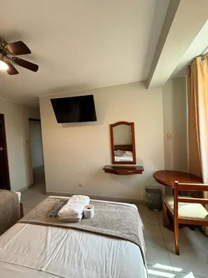 a bedroom with a bed and a mirror and a table at Hotel JOMA in San Vicente de Cañete