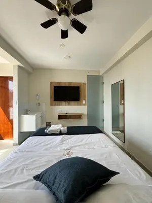 a bedroom with a large bed with a ceiling fan at Hotel JOMA in San Vicente de Cañete