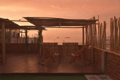 a deck with chairs and a pergola and the ocean at Casa mar surfhouse in Punta Hermosa