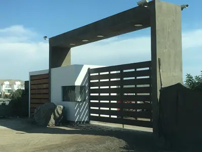 a building with a gate with a person standing next to it at Casa de Playa frente al mar en Chocalla, Asia in Asia