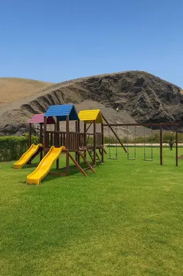 a row of playground equipment in a field of grass at Casa de Playa frente al mar en Chocalla, Asia in Asia