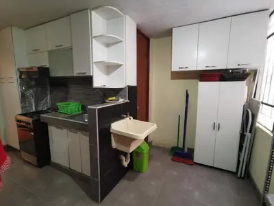 a kitchen with a sink and white cabinets at Amplio, y confortable departamento en San Miguel in Lima