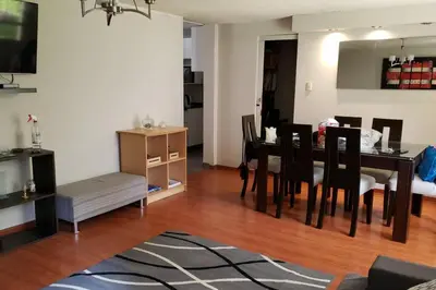 a living room with a dining room table and chairs at Amplio, y confortable departamento en San Miguel in Lima