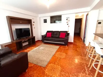 a living room with black leather furniture and a flat screen tv at Cuesta del Inka in Cusco