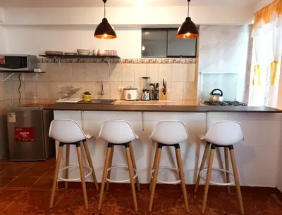 a kitchen with four bar stools in front of a counter at Cuesta del Inka in Cusco