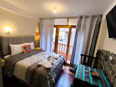 a bedroom with a bed and a sliding glass door at intikilla hostal in Ollantaytambo