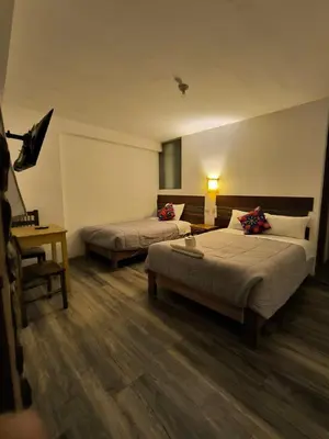 a hotel room with two beds and a desk at hostal Balcon de Piedra in Urubamba
