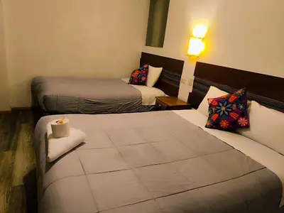 a hotel room with two beds and a couch at hostal Balcon de Piedra in Urubamba
