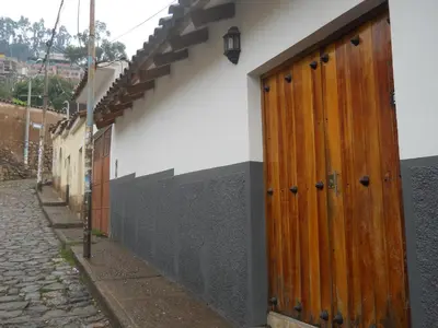 a building with a wooden door on the side of a street at Hostal Goya Andina in Cusco