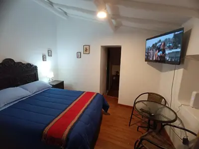 a bedroom with a bed and a flat screen tv at Mini Apart II - Sumaq Wasi ALBA in Cusco