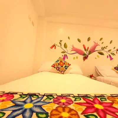 a bedroom with a bed with a flower mural on the wall at Hotel Ruta Amazónica Machupicchu in Machu Picchu
