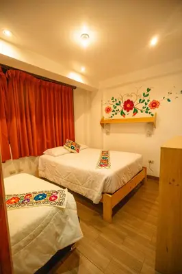 a room with two beds and a window at Hotel Ruta Amazónica Machupicchu in Machu Picchu
