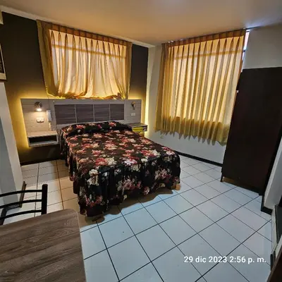 a bedroom with a bed with a floral bedspread at Hostal La Cascada in Lima