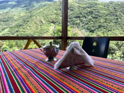 a table with a tea pot and a napkin on it at Eco Inca Trail Lodge Lucmabamba in Cusco