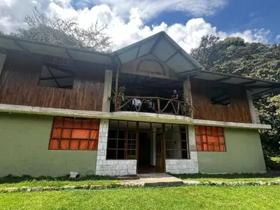 a house with two people on the balcony at Eco Inca Trail Lodge Lucmabamba in Cusco