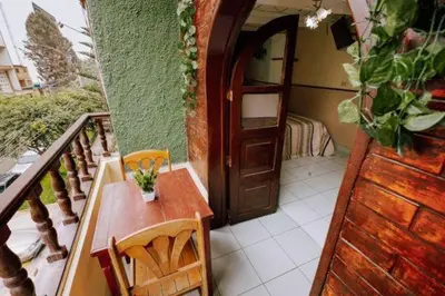 a balcony with a wooden door and a table and chairs at Residencial San Felipe in Lima
