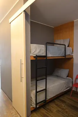 a bunk room with two bunk beds and a door at Casa sabina hostel in Lima