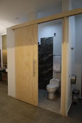 a bathroom with a toilet and a sliding door at Casa sabina hostel in Lima