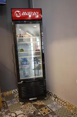 an empty coca cola refrigerator sitting on a floor at Casa sabina hostel in Lima