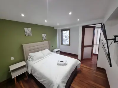 a bedroom with a white bed and green walls at Acogedor 2BR Center Miraflores - Balta in Lima