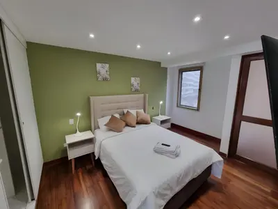 a bedroom with a large white bed and green walls at Acogedor 2BR Center Miraflores - Balta in Lima