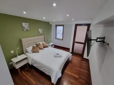 a bedroom with a large white bed and green walls at Acogedor 2BR Center Miraflores - Balta in Lima