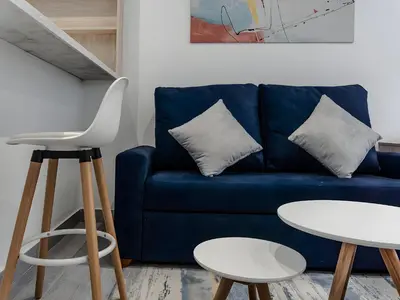 a blue couch in a living room with a table and stool at Moderno 2BR Center Miraflores- Balta 301 in Lima