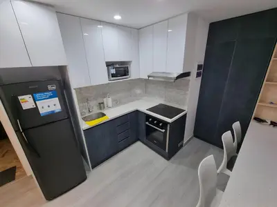 a small kitchen with a black refrigerator and white cabinets at Moderno 2BR Center Miraflores- Balta 301 in Lima