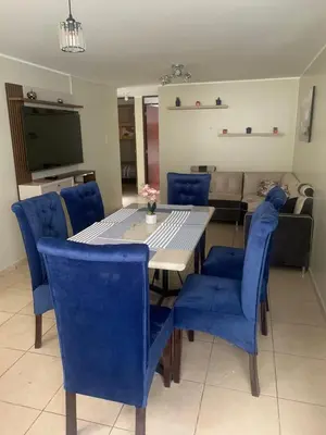 a dining room with a table and blue chairs at Apartamento LA ALBORADA para 7 con cochera in Huancayo