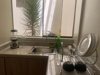 a kitchen sink with a dish drying rack next to it at Apartamento LA ALBORADA para 7 con cochera in Huancayo