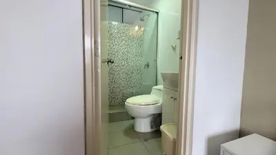 a bathroom with a toilet and a glass shower at Acogedor 2BR Miraflores - Tovar in Lima