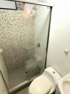 a bathroom with a toilet and a glass shower at Acogedor 2BR Miraflores - Tovar in Lima