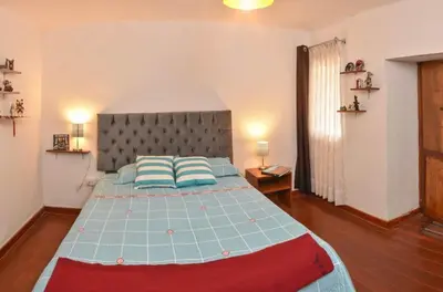 a bedroom with a large bed with a gray headboard at Apu House Minidepartamento in Cusco