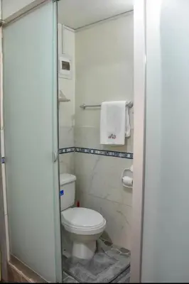 a small bathroom with a toilet and a towel at Apu House Minidepartamento in Cusco