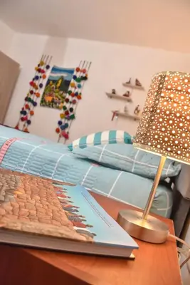 a table with a book and a lamp on a table at Apu House Minidepartamento in Cusco