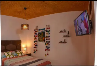 a bedroom with a bed and a tv on the wall at Apu House Monoambiente in Cusco