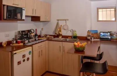 a kitchen with a table with a bowl of fruit on it at Apu House Monoambiente in Cusco