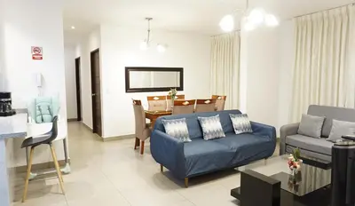 a living room with a couch and a dining room at APARTAMENTOS PRIVADOS Lima Airport Perú in Lima