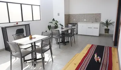 a dining room with tables and chairs and a kitchen at APARTAMENTOS PRIVADOS Lima Airport Perú in Lima