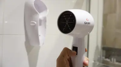 a person holding a hair dryer in their hand at APARTAMENTOS PRIVADOS Lima Airport Perú in Lima